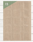 A4 Bogen mit 15 unbedruckten Kraftpapier Etiketten 50 x 50 mm auf weißem Holztisch. Es sind 15 bedruckbare Etiketten auf dem Bogen.